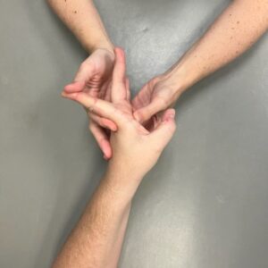 Demonstration of extrinsic long flexor stretch. Hands-on therapeutic intervention.